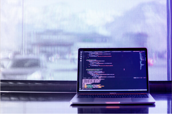 Laptop on a desk with code