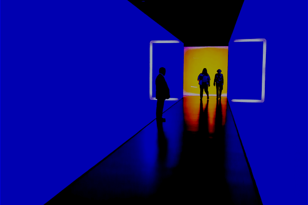 Backlit people walking down a blue hallway