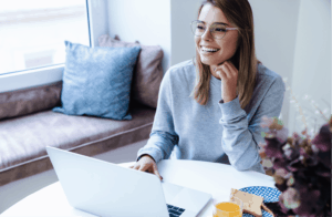 Lady sitting at desk with open laptop smiling